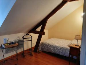 a bedroom with a bed and a wooden floor at Ferme des capucines 