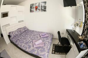 a small room with a bed with purple sheets at Etiquette Studios Mamaia in Constanţa