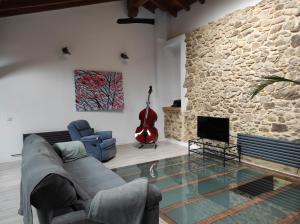 sala de estar con sofá y pared de piedra en Caserio en Elorrio, en Elorrio