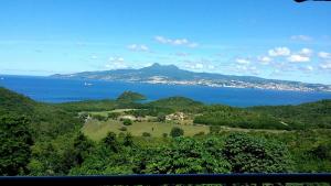 a view of the ocean and a mountain at Bleu topaze - vue imprenable - Les Anses d'Arlet in Les Anses-dʼArlets