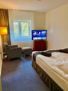 a hotel room with a bed and a flat screen tv at Słupsk forest PREMIUM HOTEL APARTAMENT M6 - Kaszubska street 18 - Wifi Netflix Smart TV50 - two bedrooms two extra large double beds - up to 6 people full - pleasure quality stay in Słupsk