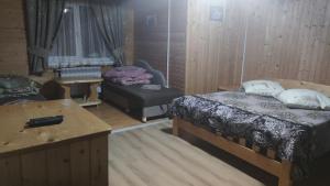 a room with two beds and a table and a couch at Sadyba Geredzhuka in Vorokhta