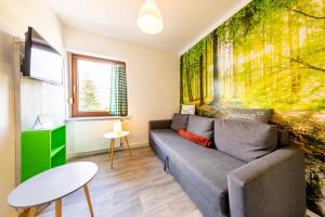 a living room with a couch and a wall mural at Pension Dorfliebe in Sondershausen