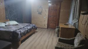 ボロフタにあるSadyba Geredzhukaのベッドルーム1室(ベッド1台、椅子1脚、ドア付)