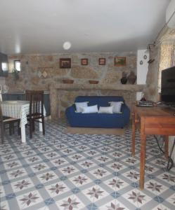 ein Wohnzimmer mit einem blauen Sofa und einem Tisch in der Unterkunft Casa da Rosa Linda in Orca