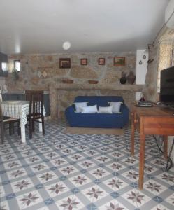 a living room with a blue couch and a table at Casa da Rosa Linda in Orca