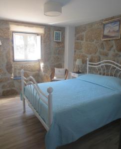 ein Schlafzimmer mit einem Bett, einem Stuhl und einem Fenster in der Unterkunft Casa da Rosa Linda in Orca
