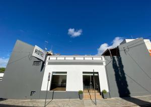 a white building with a hotel sign on it at Vitória Hotel in Monte Alto