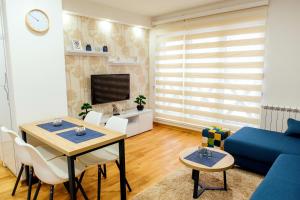 ein Wohnzimmer mit einem Tisch und einem blauen Sofa in der Unterkunft Apartman Happy day Divčibare in Divčibare