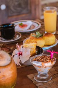 un tavolo sormontato da piatti di cibo e bevande di Pousada Lua Cheia Caraíva a Caraíva