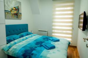 ein Schlafzimmer mit einem blauen Bett mit blauer Decke in der Unterkunft Apartman Happy day Divčibare in Divčibare
