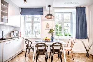 a kitchen with a table and chairs in a room at Family Luxury Nature Apartment, 1-6, 2 sypialnie i salon, 100m Bazylika in Gdańsk