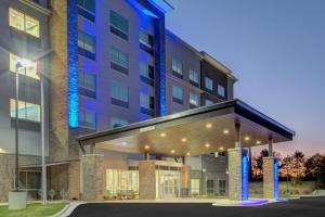 un gran edificio con un edificio con luces azules en Holiday Inn Express & Suites Charlotte Southwest, an IHG Hotel, en Charlotte
