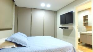 sypialnia z łóżkiem i telewizorem z płaskim ekranem w obiekcie Barra Bali Apartamento 06 - Paraíso à Beira Mar w mieście Barra de São Miguel