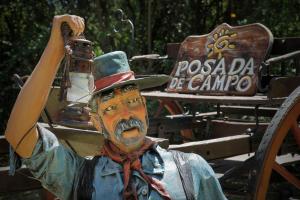 uma estátua de um homem de chapéu segurando uma lâmpada em Posada de Campo - Hotel Boutique - Adults Only em Villa General Belgrano