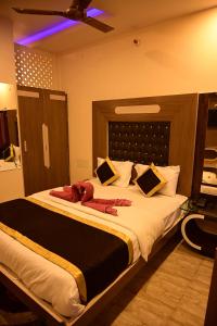 a bedroom with a large bed with a ceiling at Hotel Comfort and Terrace Lounge in Deoghar
