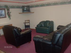 een woonkamer met 2 leren stoelen en een televisie bij King's Inn of Platte in Platte
