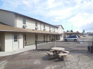 un banco de picnic frente a un edificio en King's Inn of Platte, en Platte