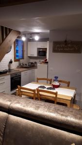 eine Küche mit einem Tisch und Stühlen im Zimmer in der Unterkunft Duplex 6-8 pers, avec garage, WIFI, calme, proche des pistes, top équipé et linges fournis, vue magnifique in Saint-Gervais-les-Bains