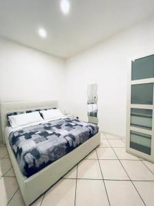 ein weißes Schlafzimmer mit einem Bett und einer Kommode in der Unterkunft POSILLIPO 27 in Neapel