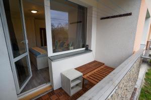 un pequeño porche con banco y ventana en Apartment Ivet en Hazlov
