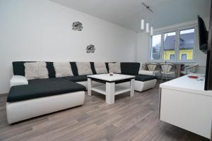 ein Wohnzimmer mit einem Sofa und einem Tisch in der Unterkunft Apartment Ivet in Hazlov