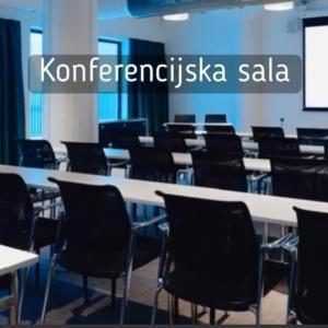 una sala de conferencias con mesas, sillas y una pantalla en Silver Top Kopaonik en Kopaonik