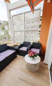 una sala de estar con 2 sofás y una mesa con flores en Apartment Orlando Tenerife Sur DUMBO, en Adeje