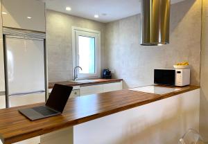 a laptop sitting on a counter in a kitchen at Puerto Banus Jardines del Puerto Apartment for up to 6 Gardens, pools, garage, wifi, terrace in Marbella