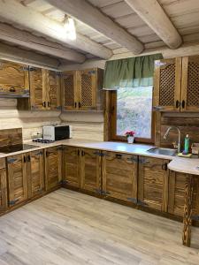 a kitchen with wooden cabinets and a sink at Смарагдовий пагорб in Plav'ya