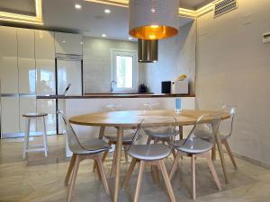 a dining room table and chairs in a kitchen at Puerto Banus Jardines del Puerto Apartment for up to 6 Gardens, pools, garage, wifi, terrace in Marbella