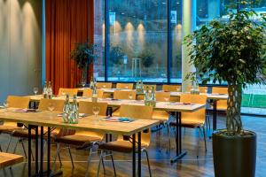 a restaurant with tables and chairs and a potted plant at Hanse Hotel Attendorn in Attendorn