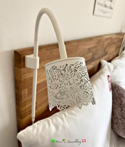 a white lamp on the headboard of a bed at Haus Lannachberg in Lannach