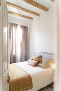 een slaapkamer met een bed met witte lakens en een raam bij Apart luminoso, céntrico y a 2 min de la playa in Sant Feliu de Guixols