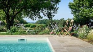 a swimming pool in a yard with a garden with flowers at Maison des Quatre Saisons in Les Esseintes