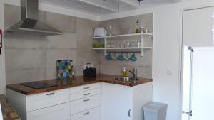 a kitchen with white cabinets and a sink at A Mansão do Mé-Mé in Manteigas