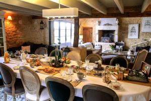 a dining room with a long table and chairs at Maison des Quatre Saisons in Les Esseintes