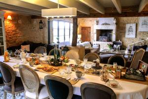 uma sala de jantar com uma mesa longa e cadeiras em Maison des Quatre Saisons em Les Esseintes
