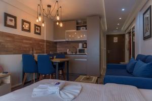 een woonkamer met een blauwe bank en een keuken bij Premier 29 Milmari Resort Wellness&Spa in Kopaonik