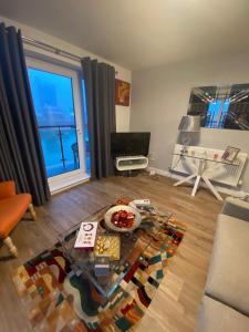 a living room with a table and a large window at Luxury Riverside 2 bedroomed Apartment with Balcony in Newport