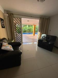 a living room with two chairs and a sliding glass door at Studio Pilon De Pavones in Pavones