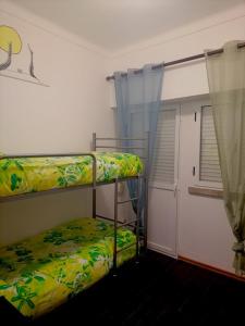 een slaapkamer met 2 stapelbedden en een raam bij Casa das 4 estações in Castelo Branco
