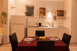 a kitchen with a table and chairs and a kitchen with a refrigerator at Gites de la Lurette - agréable T2 indépendant dans cadre calme et verdoyant in Cazilhac