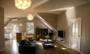 a living room with a couch and a tv at Vecbulduri Apartment Jurmala in Jūrmala