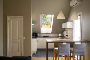 a kitchen with a table and chairs and a window at Vecbulduri Apartment Jurmala in Jūrmala