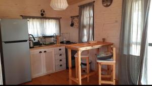 a kitchen with a refrigerator and a table in a room at Ocean Paradise 1 in Punta Del Diablo +10 photos