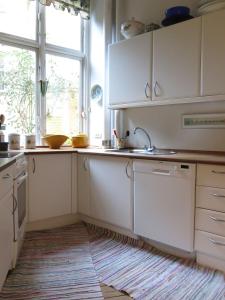 cocina con armarios blancos, fregadero y ventana en ApartmentInCopenhagen Apartment 931, en Copenhague