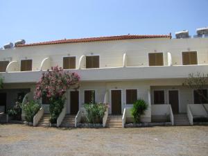 a large white building with flowers in front of it at Skoutari Beach Hotel in Skoutari