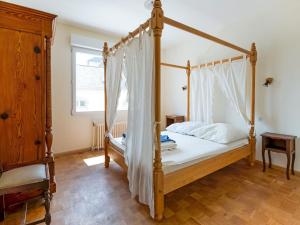 1 dormitorio con cama con dosel y ventana en Villa is approx 100 metres from the Atlantic en Le Pouldu