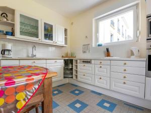 una cocina con armarios blancos y una ventana en Villa is approx 100 metres from the Atlantic en Le Pouldu